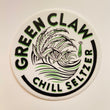 Circle sticker with arching words over the top reading “Green Claw” and arching under reading “Chill Seltzer” in the center is a rolling wave of cannabis leaves and a small UFO beaming up a cow to the right of the waves. Text and image are black with lime green text shadow.