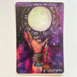 Square art sticker with image of a hand with long nails, jewelry, and tattoos reaching up towards the moon that is surrounded by symbols of the zodiac. Behind the hand and moon the background is a pink galaxy with stars.