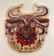 Art sticker of a brown bull with 6 eyes and 6 horns and 4 tusks. Blue glass eye “nazar” pendants hanging from each horn and more along a beaded necklace. A single blue eye bead hangs from a cobweb shaped headpiece on the forehead. Sandalwood prayer beads wrap around the bull’s nose and around its neck. Whimsical script along the bottom meant to invoke protection and guardians of dreams, but isn’t a language.