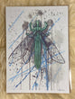 Painting of a green dragonfly on a splatter painted background. The body of the dragonfly is in the shape of a green tourmaline crystal.